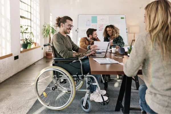 Therapeutin arbeitet mit einer Patientin im Rollstuhl im Gruppenraum