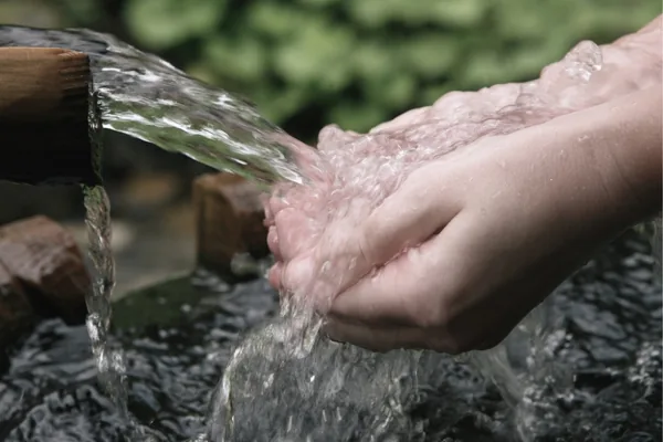 Hände unter fließendem Wasser bei einer Kneipp-Anwendung